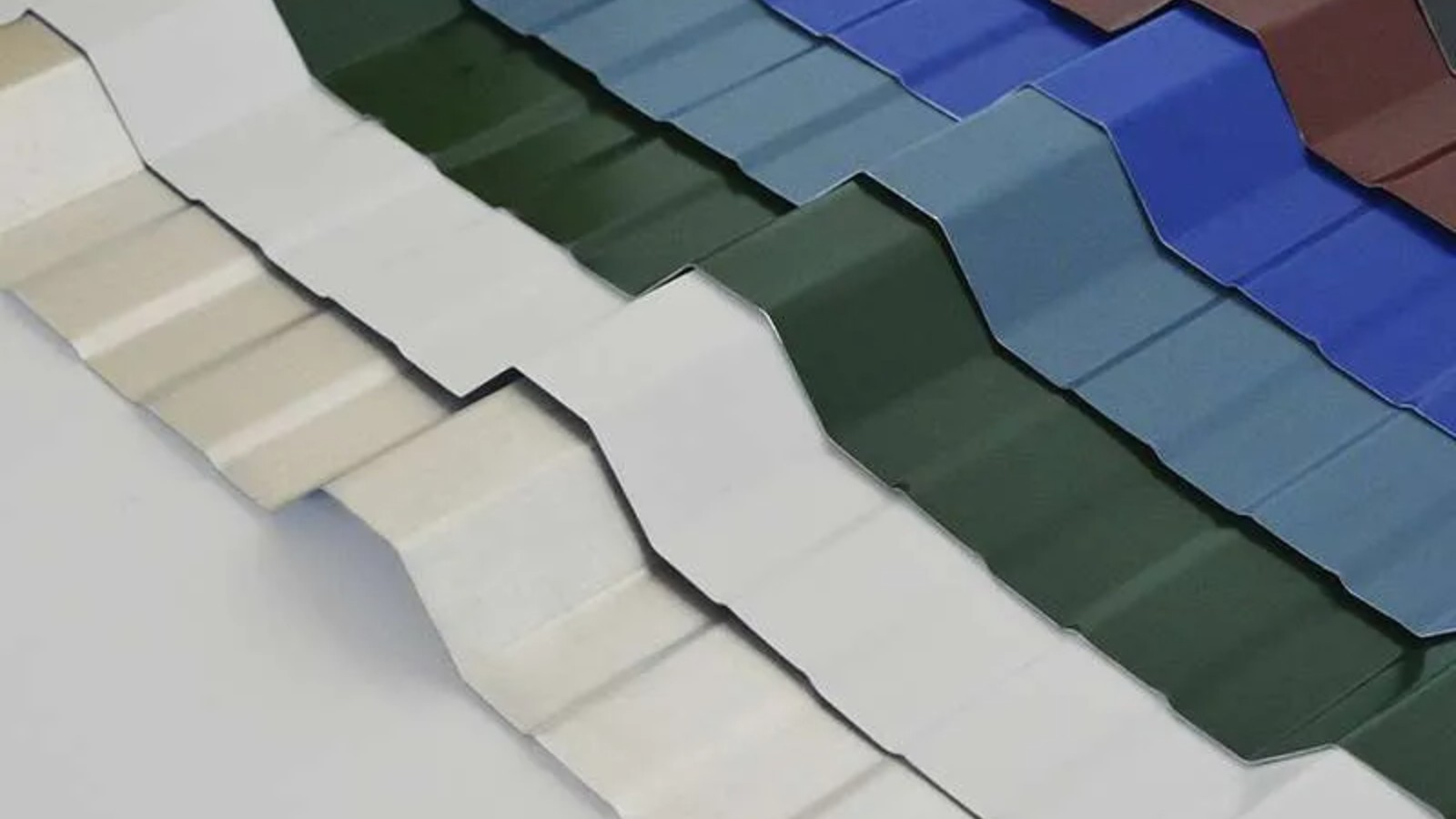 Chapas de techo perfiladas sinusoidal y T-101 apiladas en playón industrial, acero galvanizado conformado en frío