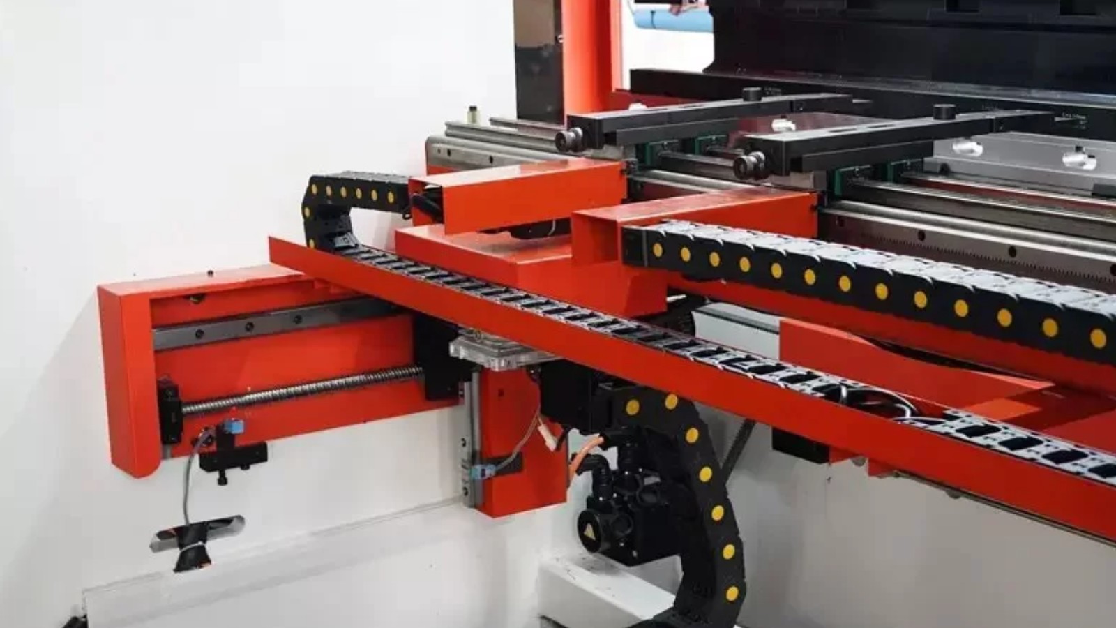 Plegadora CNC en operación con chapa de acero estructural y panel de control táctil visible